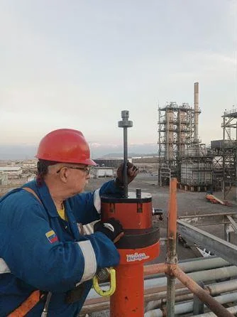 Operación técnica Técnico operando maquinaria de hot tapping en una instalación industrial